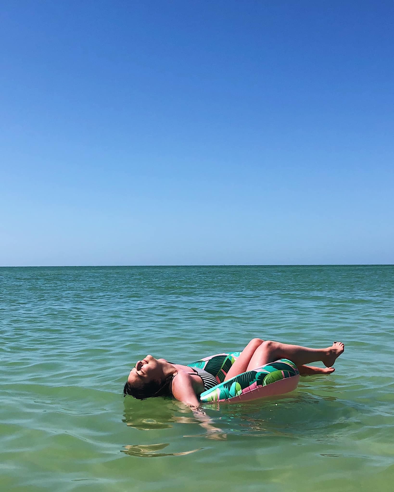 Floating in the ocean under palms